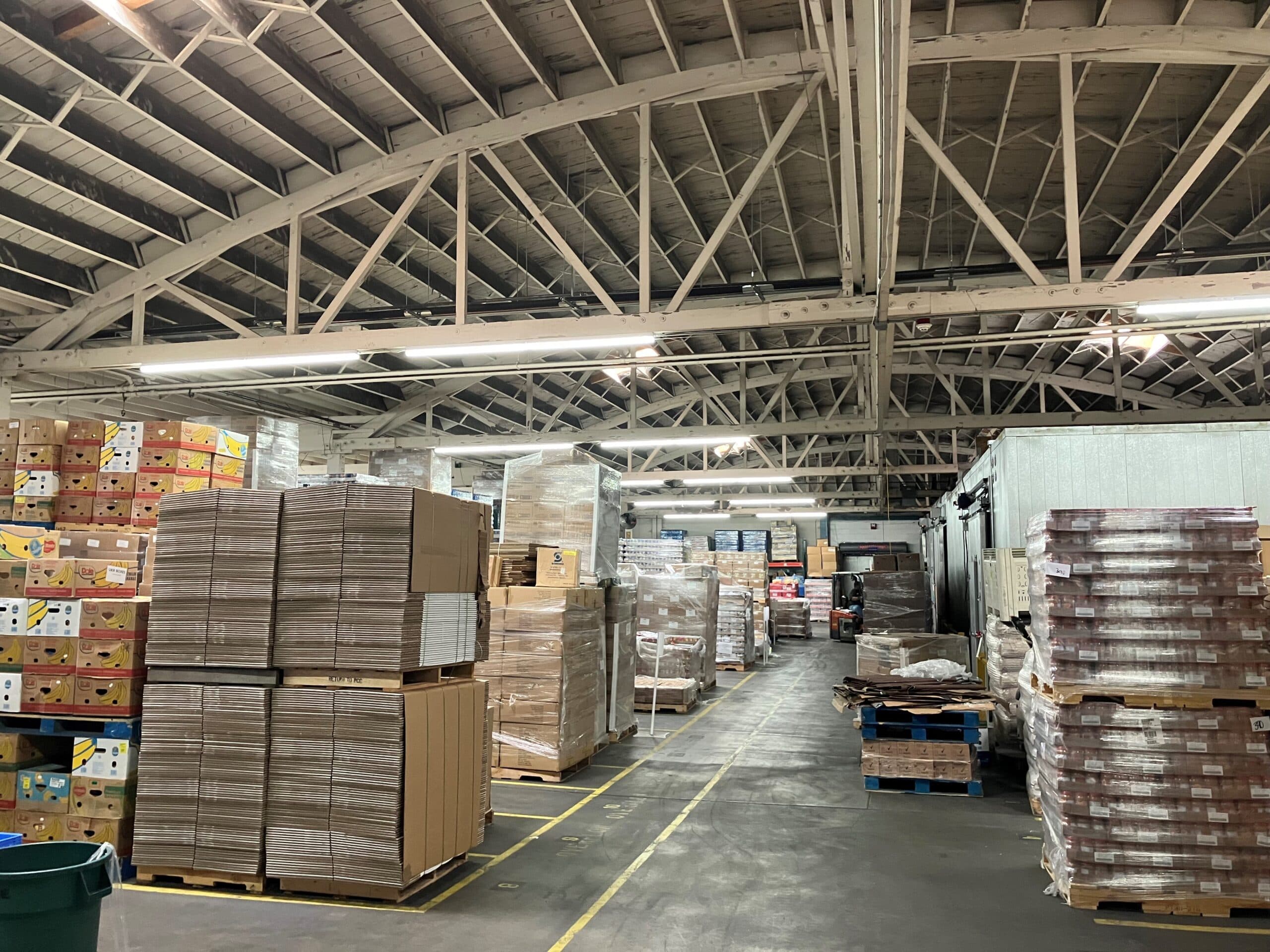 Linear LED fixtures over pallet racking in a food distribution warehouse